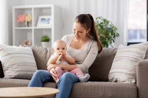 Mother and little baby with teething toy at home Stock Photos