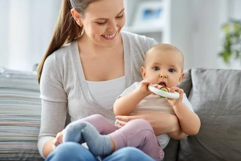 Mother and little baby with teething toy at home Stock Photos
