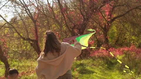 Mother and son (4-6 years old) fly a kite in a countryside setting on an autumn Stock Footage 289736795