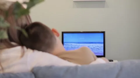 Mother and son bond while watching TV. The family has a good time together Stock Footage 274772893