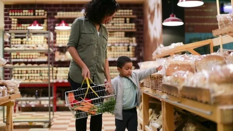 Mother and son buying bread in grocery store Stock Footage