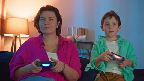 Mother and son concentrating while playing video games Stock Footage 307071172