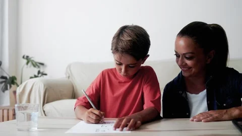 Mother and son doing homework at home living room. Mom help child boy  Stock Footage 265166466