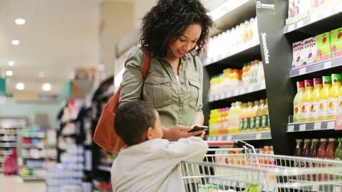 Mother and son doing weekly shop in grocery store Stock Footage 73506945