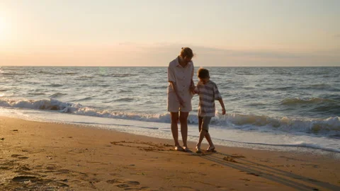 Mother and Son Drawing Patterns in the Sand with Feet Stock Footage 317905246