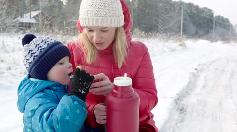 Mother and Son Drinking Hot Beverage from the Thermos Bottle Outdoor Stock Footage 60387819