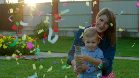 Mother and Son Exploding Party Cracker and Watching Confetti Stock Footage 56254025