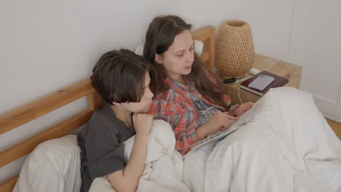 Mother and son exploring a book, sparking curiosity and learning together Vidéo 317004754