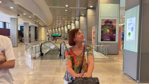 Mother and son happily chatting inside a bright terminal Vídeo Stock 344571981