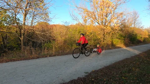 Mother and son having fun outdoors, riding a trail in autumn fall season Stock Footage 141106315