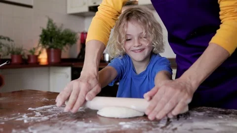 Mother and son having fun kneading dough inside home kitchen - Family cooking  Stock Footage 233171507