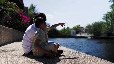 Mother and son having fun sitting on dock by the sea. Travel holiday vacations Stock Footage 274096243