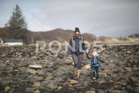 Mother And Son Holding Hands Walking On Rocks