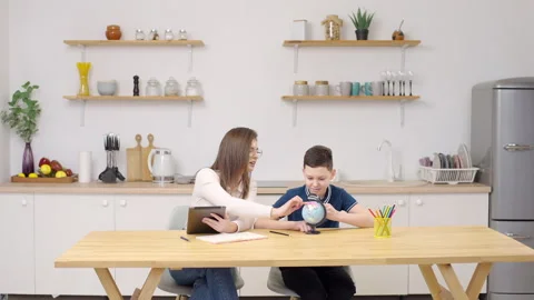 Mother and son in kitchen with tablet for studying, learning or teaching at home Video stock 275845944