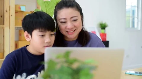 Mother and son laughing while looking computer laptop. 库存影片 83050877