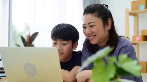 Mother and son laughing while looking computer laptop. Vidéo 83051283