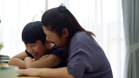 Mother and son laughing while looking computer laptop. 库存影片 83052092