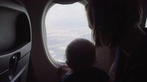 Mother And Son Looking At Clouds From Airplane While Traveling On Vacation - Stock Footage 204061413