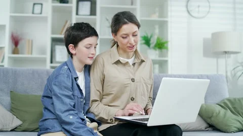 Mother and son make online purchases shopping, buying on internet using a laptop Stock Footage 238630454