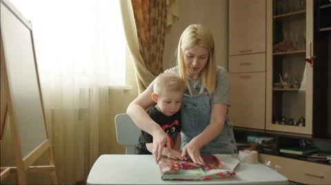 Mother and Son Packing a Present Stock Footage 60361714