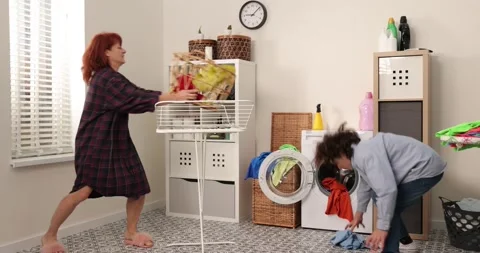 Mother and son playing doing household chores. Family having fun hanging clothes Stock Footage 178481499