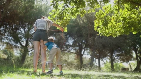 Mother and son playing with a flying toy in the park Stock Footage 322134619