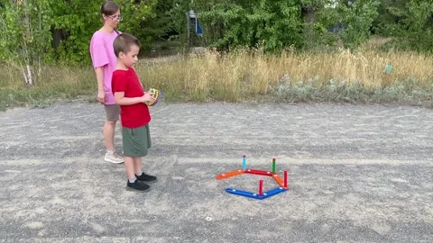 Mother and Son Playing a Ring Toss Game Outdoors Stock Footage 316589693