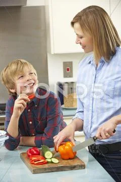 Mother and son preparing food in domestic kitchen Stock Photos