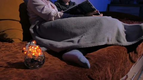Mother and son read bedtime stories. Covered with a plaid. Tells stories. Stock Footage 131043192