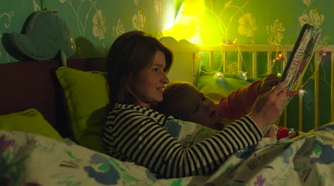 Mother and Son Reading Book in Bed Stock Footage 56721735