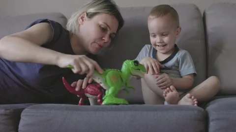 Mother and son sit on couch playing with toys together child development playful Stock Footage 280608327