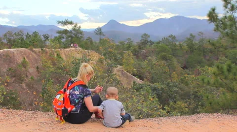 Mother and son sitting on a hill Stock Footage 64207751