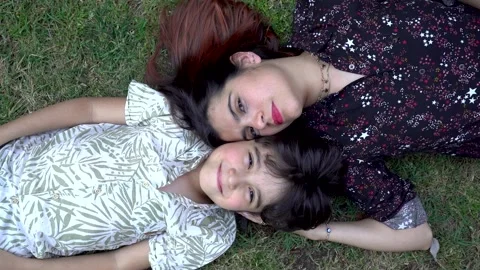 Mother and son smile while lying in a park and smiling towards the sky Stock Footage 141987046