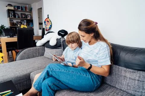 Mother and son on the sofa using digital tablet. Happy mom and little boy using Foto stock