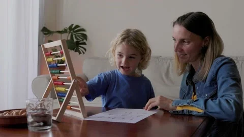 Mother and son studying math with abacus for school class inside home - Family Stock Footage 233130318