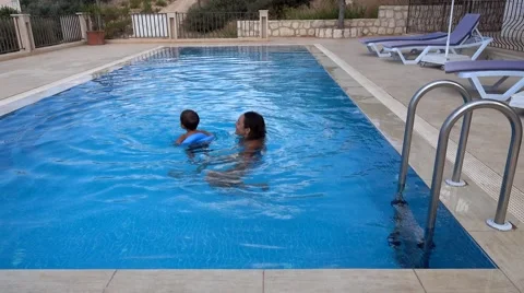 Mother and son swimming in swimming pool Stock Footage