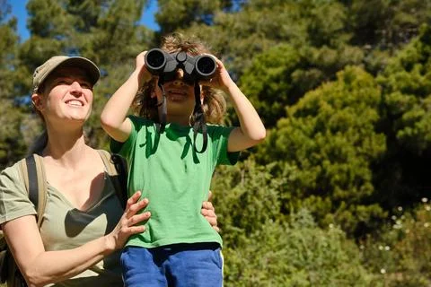 Mother and son using binoculars in nature Stock Photos