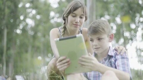 Mother and son using digital tablet outdoors Video stock 75168996