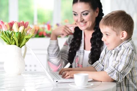 Mother and son using modern laptop at home Stock Photos