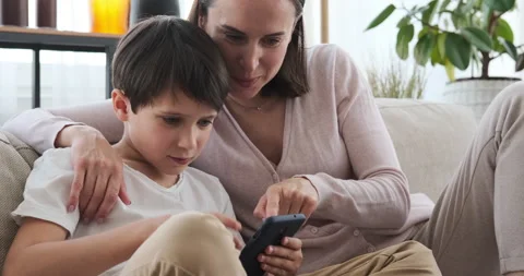 Mother and son using phone on sofa at home Stock Footage 133202137