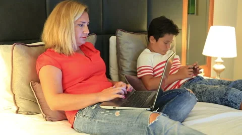 Mother and son using smartphone and laptop in the bedroom Stock Footage 66467486