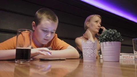 Mother and son using smartphones in the restaurant Stock-Footage 79387186