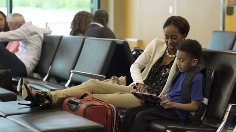 Mother and son using a tablet at an airport 動画素材 77078491