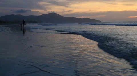 Mother and son walking along sunset beach in Kota Kinabalu Stock Footage
