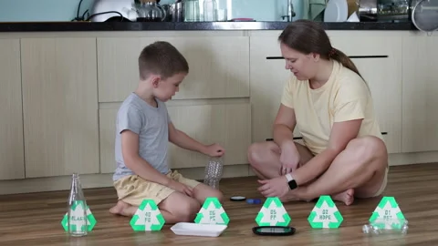 Mother and son work together at home sorting various types of waste. Stock Footage 294181198