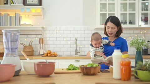 Mother and tiny child in the kitchen preparing dinner Video stock 288171631