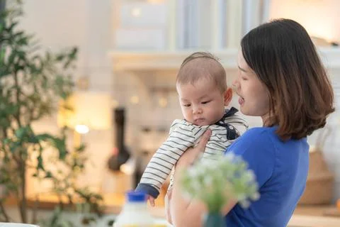 Mother and tiny child in the kitchen preparing dinner Mother and tiny chil... 스톡 사진