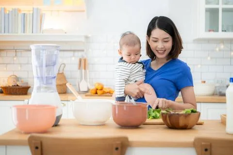 Mother and tiny child in the kitchen preparing dinner Mother and tiny chil... Stock Photos