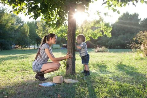 Mother and toddler playing the hide-and-seek outdoors Stock Photos