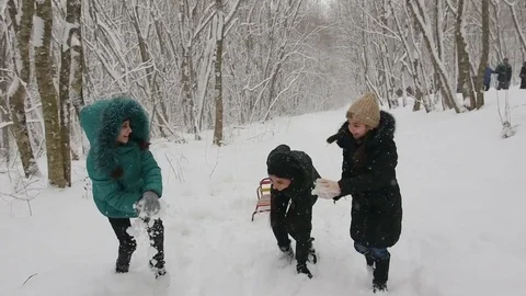 Mother and two daughters playing snowballs Stock Footage 72372550